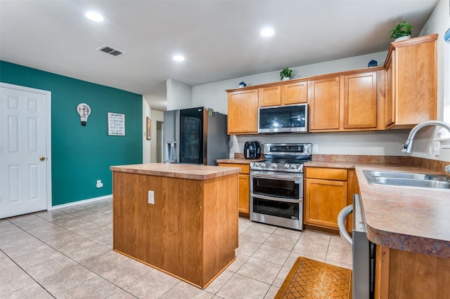 113 Cayman Dr, Lancaster, TX 75146 - kitchen with appliances with stainless steel finishes, a center island, light tile patterned flooring, recessed lighting, and light countertops