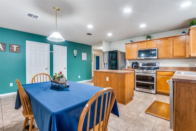 113 Cayman Dr, Lancaster, TX 75146 - kitchen featuring stainless steel appliances, a center island, light tile patterned floors, recessed lighting, and hanging light fixtures