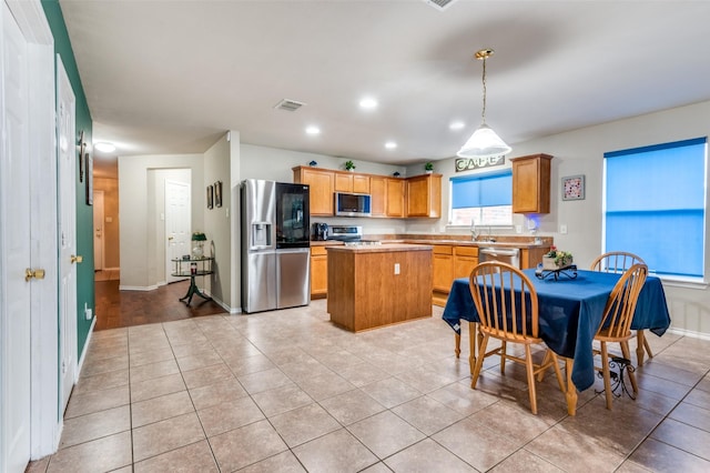 113 Cayman Dr, Lancaster, TX 75146 - kitchen featuring appliances with stainless steel finishes, a center island, light countertops, recessed lighting, and light tile patterned flooring