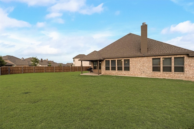 629 Dean Box Dr, Waxahachie, TX 75165 - rear view of house featuring roof with shingles, a fenced backyard, a patio area, a chimney, and brick siding
