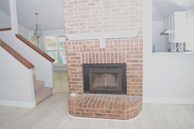 803 Ashmount Ln, Arlington, TX 76017 - detailed view of wood finished floors, a brick fireplace, and under cabinet range hood