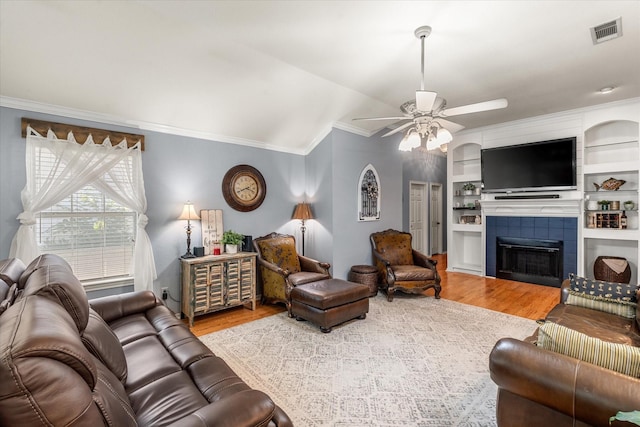152 Guadalupe Dr, Gun Barrel City, TX 75156 - living area featuring wood finished floors, ornamental molding, ceiling fan, lofted ceiling, and a tiled fireplace