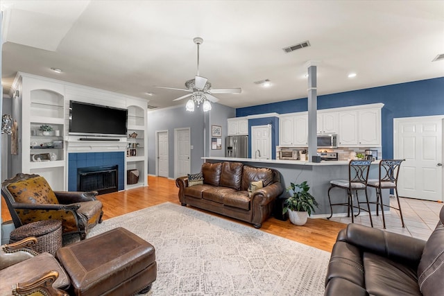 152 Guadalupe Dr, Gun Barrel City, TX 75156 - living room with ceiling fan, a tiled fireplace, light wood finished floors, and recessed lighting