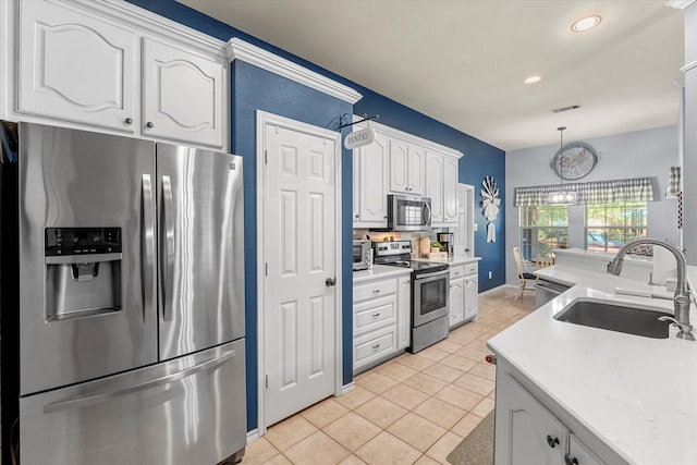 152 Guadalupe Dr, Gun Barrel City, TX 75156 - kitchen featuring appliances with stainless steel finishes, light tile patterned flooring, light countertops, hanging light fixtures, and white cabinetry