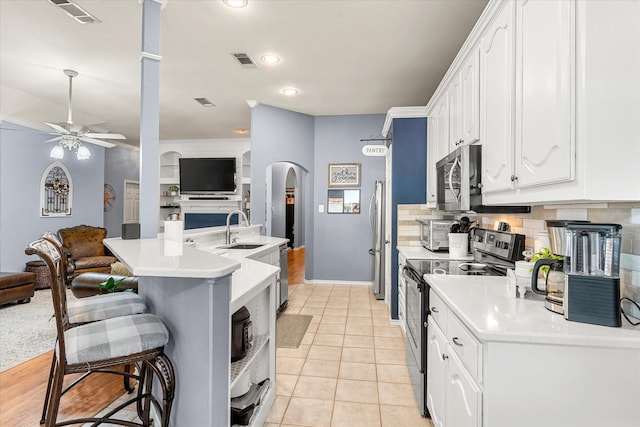 152 Guadalupe Dr, Gun Barrel City, TX 75156 - kitchen featuring stainless steel appliances, arched walkways, a ceiling fan, white cabinetry, and open floor plan