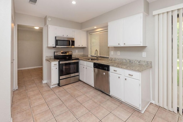 1804 Briarpath Ln, Arlington, TX 76018 - kitchen with stainless steel appliances, light tile patterned floors, white cabinets, light stone countertops, and recessed lighting