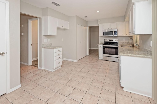 1804 Briarpath Ln, Arlington, TX 76018 - kitchen with stainless steel appliances, light tile patterned floors, white cabinetry, recessed lighting, and light stone counters