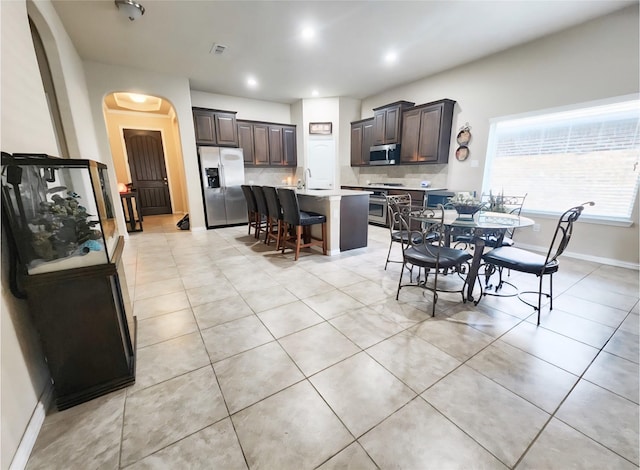 3812 Gennaker Dr, Denton, TX 76210 - dining room with arched walkways and light tile patterned floors