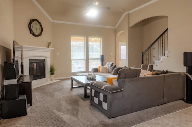 3812 Gennaker Dr, Denton, TX 76210 - carpeted living room with ornamental molding, a glass covered fireplace, stairway, arched walkways, and vaulted ceiling