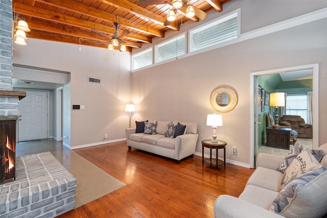 4925 Terrace Trl, Fort Worth, TX 76114 - living room with a ceiling fan, a wooden ceiling with exposed beams, a warm lit fireplace, healthy amount of natural light, and wood finished floors