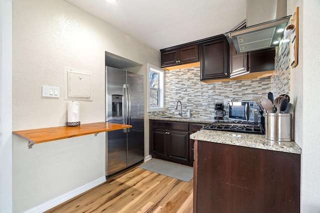 1725 Engle Ave, Dallas, TX 75224 - kitchen featuring stainless steel fridge with ice dispenser, light wood-style flooring, dark brown cabinetry, tasteful backsplash, and light stone countertops