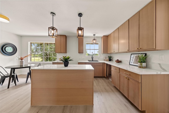 1012 W Trinity St, Groesbeck, TX 76642 - kitchen with light wood-style floors, light countertops, hanging light fixtures, and a center island