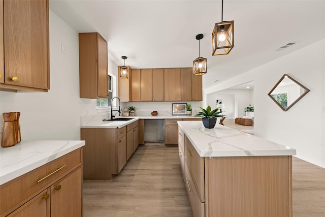 1012 W Trinity St, Groesbeck, TX 76642 - kitchen featuring light wood-style floors, a center island, and light stone countertops