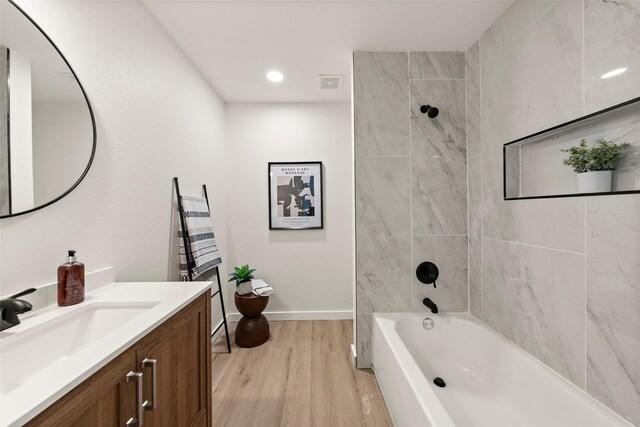 1012 W Trinity St, Groesbeck, TX 76642 - full bath with vanity, wood finished floors, washtub / shower combination, and recessed lighting