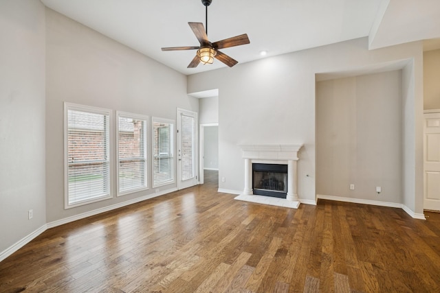 4471 Chandler Dr, Frisco, TX 75034 - unfurnished living room with ceiling fan, wood finished floors, a fireplace with raised hearth, recessed lighting, and a high ceiling