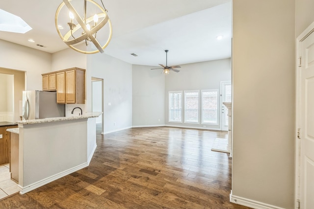 4471 Chandler Dr, Frisco, TX 75034 - kitchen featuring freestanding refrigerator, wood finished floors, ceiling fan, a skylight, and light brown cabinetry