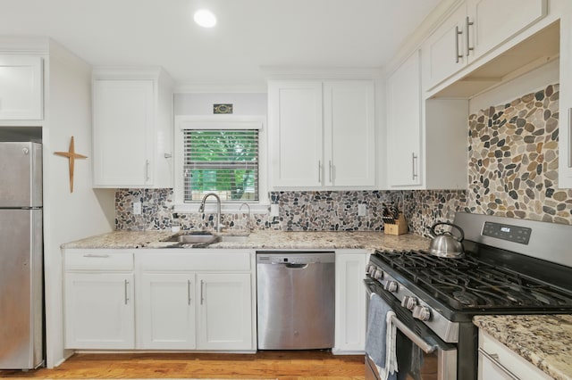 3000 Binyon St, Fort Worth, TX 76133 - kitchen featuring stainless steel appliances, white cabinets, decorative backsplash, light stone counters, and ornamental molding