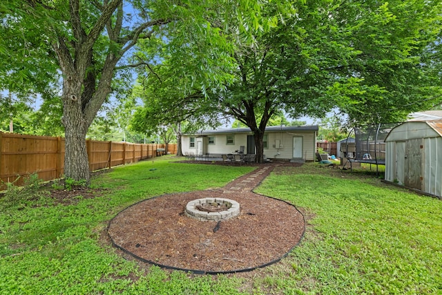 3000 Binyon St, Fort Worth, TX 76133 - fenced backyard with a trampoline, a storage shed, and a fire pit