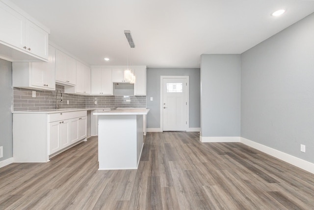 3828 Pacesetter Dr, Dallas, TX 75241 - kitchen with light wood finished floors, backsplash, white cabinetry, light countertops, and recessed lighting