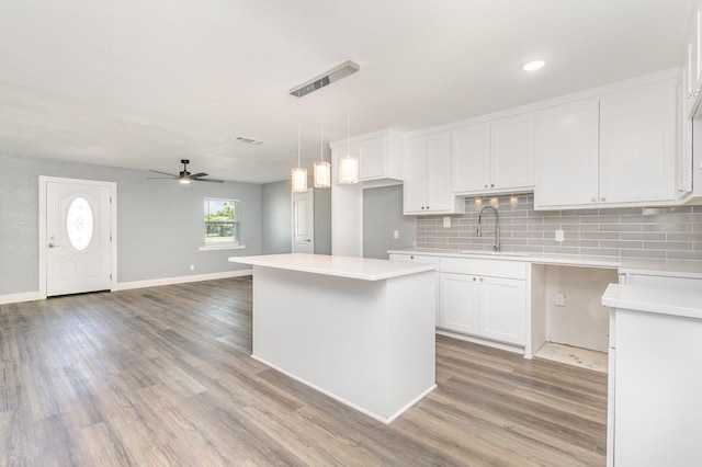 3828 Pacesetter Dr, Dallas, TX 75241 - kitchen with ceiling fan, white cabinets, tasteful backsplash, light wood finished floors, and recessed lighting