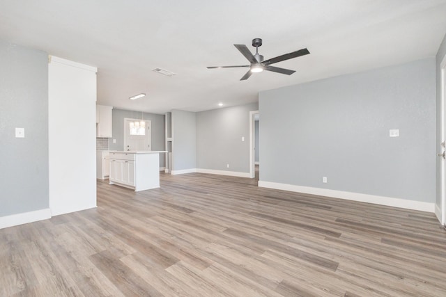 3828 Pacesetter Dr, Dallas, TX 75241 - unfurnished living room with ceiling fan, light wood-style floors, and a chandelier
