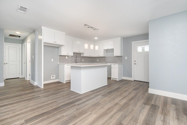 3828 Pacesetter Dr, Dallas, TX 75241 - kitchen with a center island, white cabinets, light countertops, and light wood finished floors