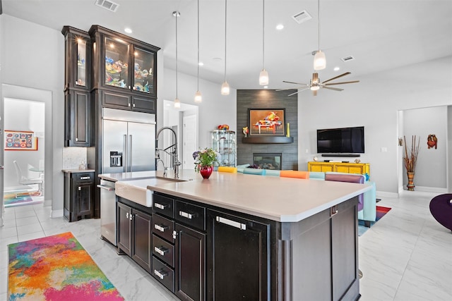 1833 Rolling Heights Ln, Fort Worth, TX 76008 - kitchen featuring light marble finish flooring, ceiling fan, appliances with stainless steel finishes, light countertops, and a high ceiling