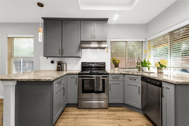 14902 Le Grande Dr, Addison, TX 75001 - kitchen with stainless steel appliances, extractor fan, gray cabinetry, and a peninsula