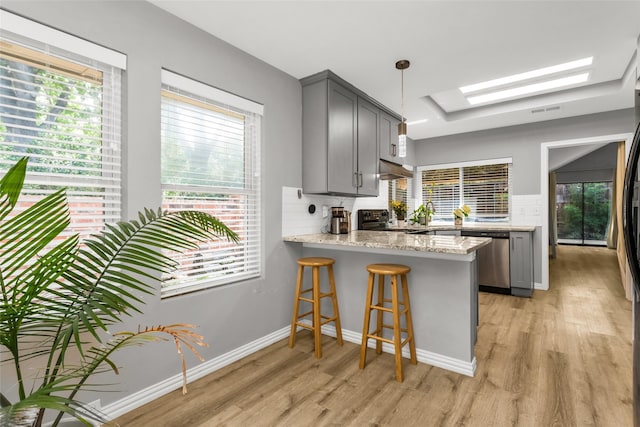 14902 Le Grande Dr, Addison, TX 75001 - kitchen featuring appliances with stainless steel finishes, gray cabinets, a skylight, and light wood-style floors
