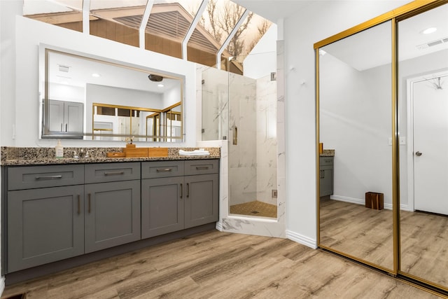 14902 Le Grande Dr, Addison, TX 75001 - bathroom featuring a marble finish shower, vanity, and wood finished floors