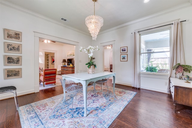 5818 Worth St, Dallas, TX 75214 - dining room featuring ornamental molding, dark wood-style flooring, and a chandelier