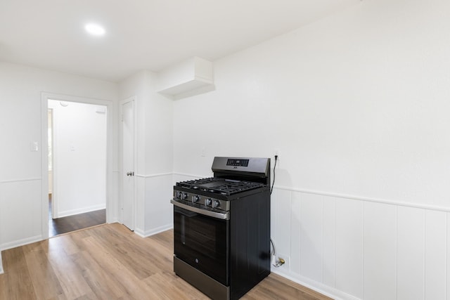 1308 Edgecliff Rd, Fort Worth, TX 76134 - kitchen with gas range, light wood-type flooring, white cabinetry, and a wainscoted wall