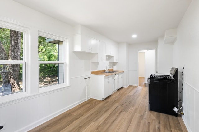 1308 Edgecliff Rd, Fort Worth, TX 76134 - kitchen featuring black range with gas stovetop, light wood-style flooring, white cabinetry, dishwasher, and light countertops