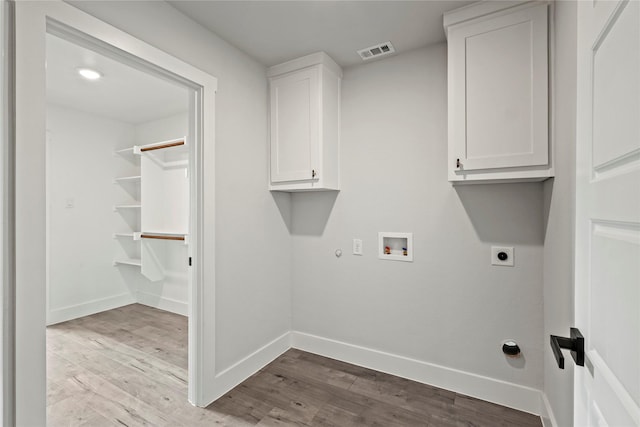 3211 Chihuahua Ave, Dallas, TX 75212 - laundry area featuring electric dryer hookup, washer hookup, wood finished floors, cabinet space, and hookup for a gas dryer