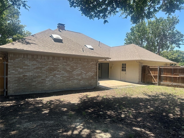1112 Ranger Ct, Plano, TX 75075 - rear view of property featuring a chimney, a patio area, a shingled roof, and brick siding