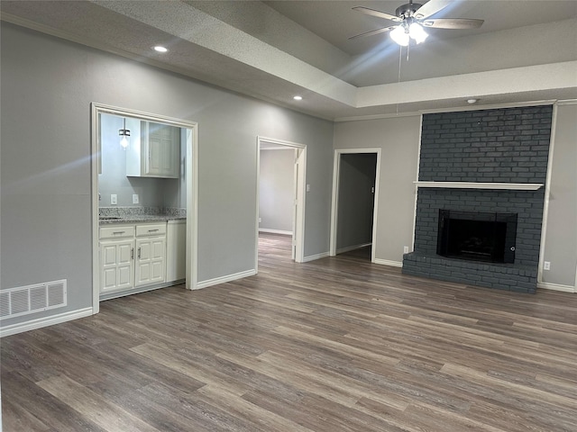 1112 Ranger Ct, Plano, TX 75075 - unfurnished living room featuring a ceiling fan, wood finished floors, a tray ceiling, recessed lighting, and a fireplace
