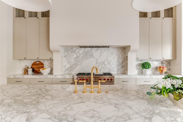 7226 Colgate Ave, Dallas, TX 75225 - kitchen featuring glass insert cabinets, decorative backsplash, and light stone counters