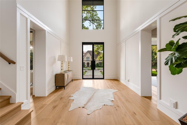 7226 Colgate Ave, Dallas, TX 75225 - entrance foyer featuring plenty of natural light, a high ceiling, stairway, and light wood-style flooring