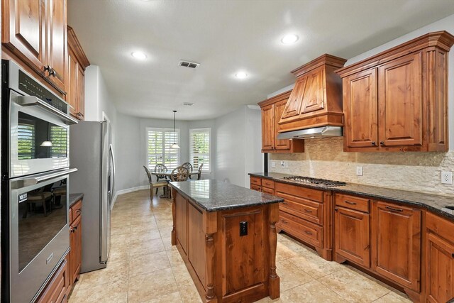 6460 Cherry Hills Dr, Frisco, TX 75036 - kitchen with appliances with stainless steel finishes, a center island, backsplash, brown cabinets, and recessed lighting
