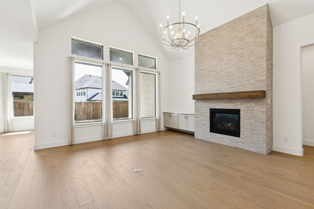 4541 Walnut Grove Ln, Prosper, TX 75078 - unfurnished living room with a chandelier, high vaulted ceiling, hardwood / wood-style flooring, and a large fireplace