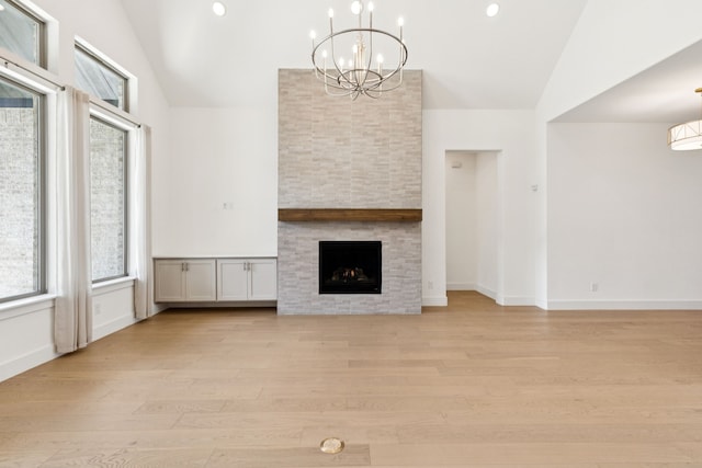 4541 Walnut Grove Ln, Prosper, TX 75078 - unfurnished living room featuring a chandelier, light wood-style flooring, a stone fireplace, recessed lighting, and high vaulted ceiling