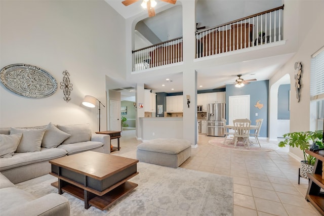 2621 Princeton Dr, Flower Mound, TX 75022 - living room featuring a ceiling fan, a high ceiling, light tile patterned floors, and arched walkways