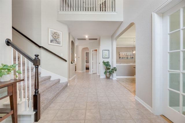2621 Princeton Dr, Flower Mound, TX 75022 - entrance foyer with arched walkways, a towering ceiling, and stairs
