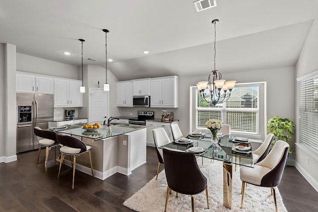 6001 Harwich Ln, Fort Worth, TX 76179 - kitchen featuring appliances with stainless steel finishes, a chandelier, an island with sink, vaulted ceiling, and dark countertops