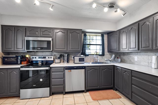 9395 Green Springs Cir, Sanger, TX 76266 - kitchen with stainless steel appliances, backsplash, light countertops, and rail lighting