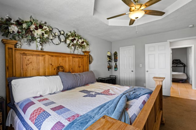 9395 Green Springs Cir, Sanger, TX 76266 - tiled bedroom with carpet floors, a ceiling fan, and a textured ceiling