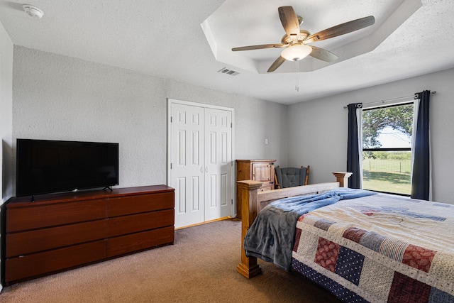 9395 Green Springs Cir, Sanger, TX 76266 - bedroom with carpet flooring, a raised ceiling, ceiling fan, a textured wall, and a closet