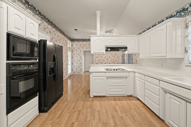6700 Crane Rd, North Richland Hills, TX 76182 - kitchen featuring black appliances, wallpapered walls, range hood, white cabinets, and light wood-type flooring