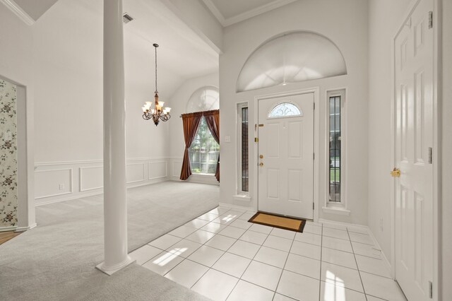 6700 Crane Rd, North Richland Hills, TX 76182 - foyer featuring light colored carpet, a chandelier, lofted ceiling, ornamental molding, and light tile patterned floors