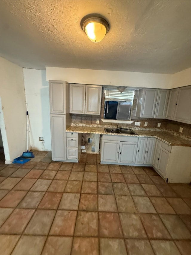 1421 Richard St, Mesquite, TX 75149 - kitchen featuring gray cabinetry, a textured ceiling, and tasteful backsplash